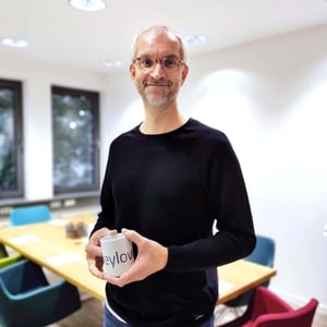 keylight team member Dr. Jan-Hendrik Prinz, Solution Architect, holding company mug in modern office environment representing company culture