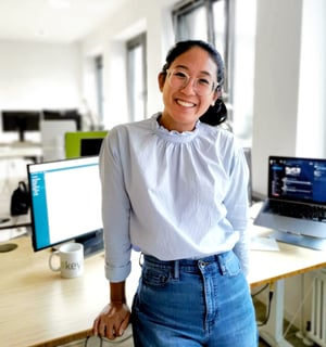 keylight team member Mallika Trakanpasakul, Software Engineer, at desk with multiple monitors in modern office representing inclusive team culture